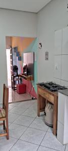 a kitchen with a stove and a table in a room at kitnet em São João Del Rei, a 11km de Tiradentes MG in São João del Rei