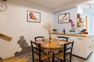 een keuken en eetkamer met een tafel en stoelen bij Charmant duplex deux chambres Saxe Gambetta in Lyon