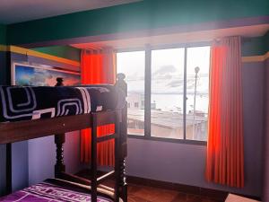a bedroom with a bunk bed and a large window at Sky Lake Backpackers Hostel in Copacabana