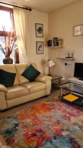 un soggiorno con un divano e un tavolo di Skye Cottage, Meadowside House, near Kingussie a Kingussie
