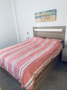 a bedroom with a bed with a red and white blanket at Fantastic apartment in Torrevieja