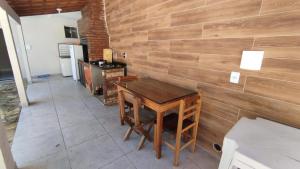 a wooden wall with a wooden table in a room at CASA 7 qts sendo 4 suites, Piscina Churrasqueira 200 m praia Anjos in Arraial do Cabo