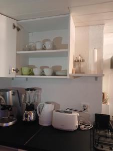 uma cozinha com electrodomésticos brancos num balcão em Ferienwohnung in Bühler em Bühler