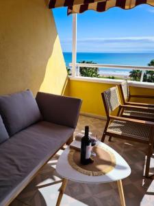 a patio with a couch and a table with a bottle of wine at Los Cuentos De Natalia / The Tales Of Natalia in Oropesa del Mar