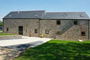 a large brick building with a staircase in front of it at Kidwelly Farmhouse B&B in Kidwelly