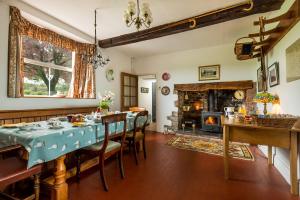 a dining room with a table and a fireplace at Kidwelly Farmhouse B&B in Kidwelly