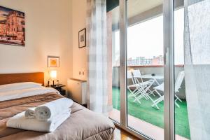 1 dormitorio con 1 cama y balcón con mesa en Masini House [Bologna Station-Center-Fiera], en Bolonia