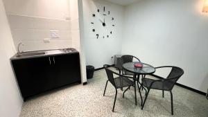 une cuisine avec une table, des chaises et une horloge murale dans l'établissement Apartaestudio Reloj, à Líbano