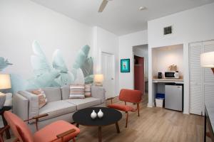 Paradise Inn - Adult Exclusive في كي ويست: غرفة معيشة مع أريكة وكراسي