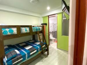 a bedroom with two bunk beds and a bathroom at Hospedaje Rocio del Mar in Cerro Azul