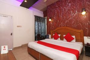 a bedroom with a large bed with red pillows at OYO Thirumal Residency in Tirunelveli