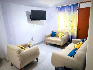 - un salon avec deux canapés et une télévision dans l'établissement Casa Privada, à Ica