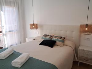 カラタユーにあるApartamentos Rúa Centro Calatayud & Balcony Apartamentの白いベッドルーム(枕付きのベッド2台付)