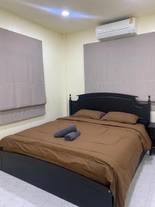Schlafzimmer mit einem großen Bett und einem Ventilator an der Wand in der Unterkunft Mee-Suk Home in Bang Hia