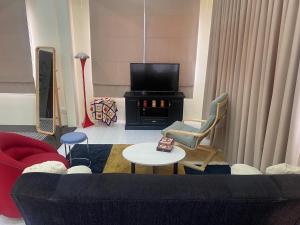 sala de estar con sofá y TV en Mee-Suk Home en Bang Hia