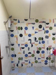 y baño con ducha y pared de azulejos. en Mee-Suk Home en Bang Hia