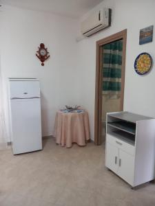 a kitchen with a table and a white refrigerator at MiraErice in Napola