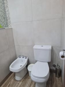 Baño blanco con aseo y lavamanos en LA GARDIA en Cañuelas