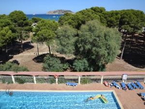 an overhead view of a swimming pool with chairs and trees at Apartamento L'Estartit, 2 dormitorios, 5 personas - ES-323-3 in L'Estartit