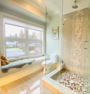 a bathroom with a toilet and a window at Vancouver Shangrila House in Richmond