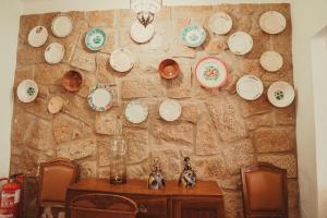 a wall with plates hanging on a stone wall at Grandma's House in Penamacor