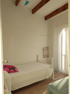 1 dormitorio con 1 cama en una habitación blanca en Sol del Este, en Es Castell