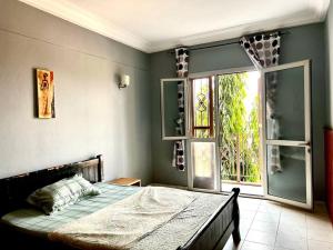Un dormitorio con una cama y una ventana grande. en Appart 3 Ch. Biteng Yaoundé, en Yaoundé