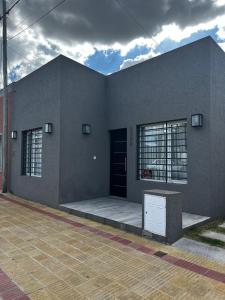 a gray building with a black door and windows at Lo de pame y Fran in Tandil