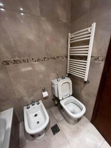 a bathroom with a toilet and a sink at Lo de pame y Fran in Tandil