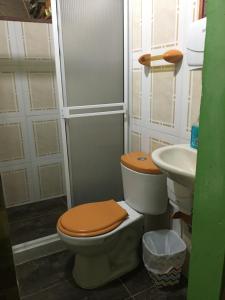 a bathroom with a toilet and a sink at Hostal Los Wichos in Minca