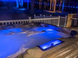 uma banheira de hidromassagem coberta de neve à noite em Lakeside Haven- Hot Tub Piano Arcade Kayaks em Lake Ariel