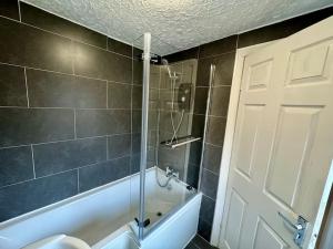 a bathroom with a shower and a tub and a toilet at Home in Sheffield with King/Twin bed in Longley