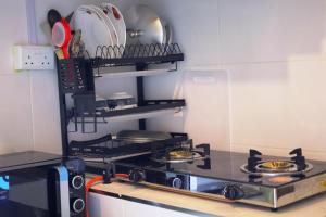a kitchen with a stove top oven in a kitchen at The Pearl Cage Gigiri-Near US Embassy in Nairobi
