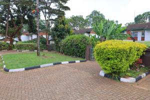 a brick sidewalk with a bush in a yard at The Pearl Cage Gigiri-Near US Embassy in Nairobi