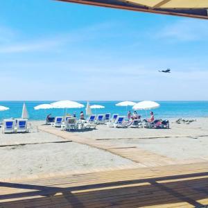 a group of people sitting on a beach with chairs and umbrellas at Sey Beach Hotel & Spa in Alanya