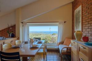 een eetkamer met een tafel en een groot raam bij [Portisco-Costa Smeralda] Villa Giardino e Vista Mare in Marina di Portisco