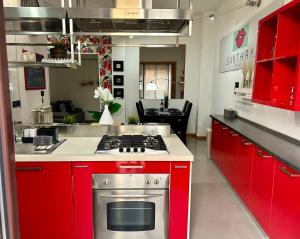 a kitchen with red cabinets and a stove top oven at Santhry House in Turin