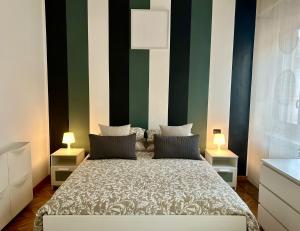 1 dormitorio con 1 cama con rayas verdes y blancas en Santhry House en Turín