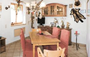 une salle à manger avec une table en bois et des chaises roses dans l'établissement Stunning Home In Reisseck-kolbnitz With Kitchen, à Zandlach