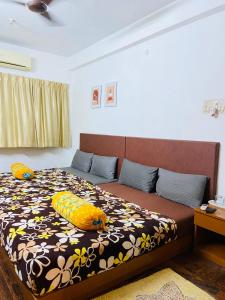 - une chambre avec un lit doté d'oreillers jaunes dans l'établissement Deer Suites and Spa- Rock Beach White Town Zone , French Quarter, Pondicherry, à Pondichéry
