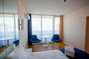 1 dormitorio con 2 mesas y 2 sillas azules en Welcome To Batumi, en Batumi