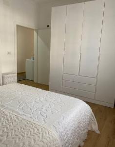 1 dormitorio con 1 cama blanca y armarios blancos en 29 Guesthouse en Bajram Curri