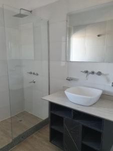 a bathroom with a sink and a glass shower at BLU APARTMENTS in San Rafael