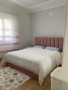 um quarto com uma cama grande e uma cabeceira rosa em 29 Guesthouse em Kolgecaj