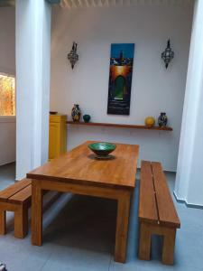 une table en bois avec un bol et un banc dans l'établissement La Maison des Amis, à Fès