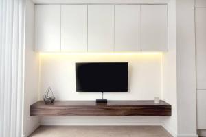 a flat screen tv sitting on a shelf in a room at Luxury London Townhouse - Hidden Gem in London