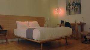 a bed with a wooden frame in a room at Hotel Brecha in Tijuana