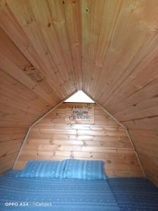 蒙圭的住宿－CASA BAHAREQUE HOSPEDAJE，木制客房的一张床位,设有木制天花板
