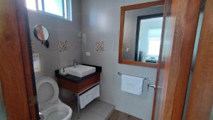 a bathroom with a sink and a toilet and a mirror at La Bocana de Quiximies Hotel in Cojimíes
