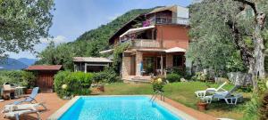 une maison avec une piscine en face d'une maison dans l'établissement Casale Massina APPARTAMENTO PERLA, à Salò